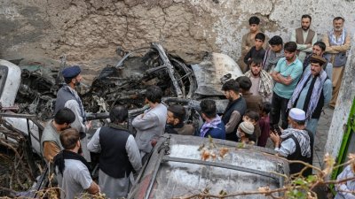 美军无人机8月30日执行的空袭行动，导致阿富汗喀布尔一个家庭的至少9人死亡，其中包括孩童。图为死者家属聚集在一所房屋内一辆受损车辆旁。-法新社-