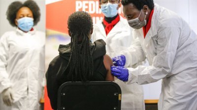 中国科兴新冠疫苗上周五（10日）在南非启动青少年临床试验。当天在比勒陀利亚的塞法科·马克加托健康科学大学，一名医护人员正为一名未成年者接种科兴疫苗。（图取自法新社）