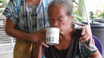失踪的老妇女安然回到家后，家人为她递上茶水。