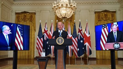 美国总统拜登（中）与通过视讯的澳洲总理莫里森（右），还有英国首相约翰逊宣布，成立一个结合军事与外交，名为AUKUS的新三方安全倡议。-法新社-