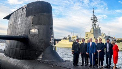 法国总统马克龙（左2）在2018年5月2日，与时任澳洲总理特恩布尔站在澳洲皇家海军运营的柯林斯级潜艇的甲板上。（图取自法新社）