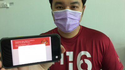 郭子毅出示事主的Mysejahtera手机应用程式上所显示的红色标志，促请有关当局解决系统技术问题。
