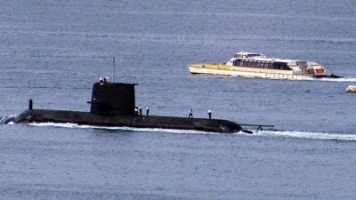 一艘渡轮在离开悉尼港时，经过澳洲皇家海军的科林斯级潜艇“沃勒”号。（图取自路透社）