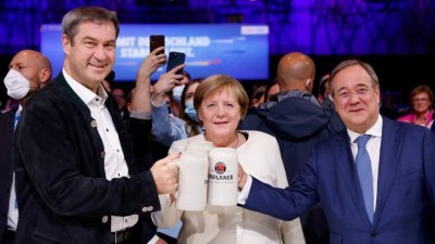 即将卸任的德国总理的默克尔（中）、基社盟主席索德（左）和联盟党总理候选人拉舍特（右），上周五在慕尼黑的拉票活动上举杯。(图取自路透社)