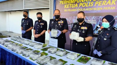 米尔法立达拉（左3）向媒体展示印尼籍毒贩企图贩运回国的冰毒，左2是霹雳州肃毒组主任李庆泉助理总监。