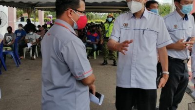 马汉顺（中）周三突击检查昔加末县三间疫苗中心，了解学生接种疫苗的过程。