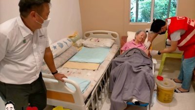 黄顺祥（左）见证一名行动不便的阿嬷在马来西亚红新月会槟州分会会员的协助下，在家完成了加强剂接种。