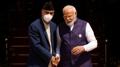 尼泊尔总理德乌帕（左）周六在印度新德里海德拉巴大厦前与印度总理莫迪握手会面。（图取自路透社）