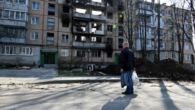 在乌克兰第2大城哈尔科夫，一名男子周日看著因战争成为废墟的5层住宅楼。（图取自法新社）