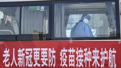 一辆停在北京市的流动疫苗接种车，挂了一块布条，敦促老年人接种新冠疫苗。（图取自法新社）