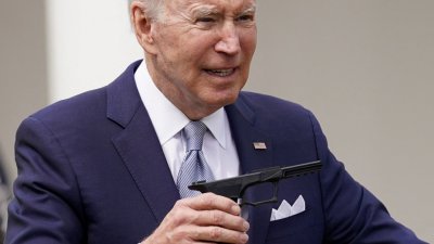 美国总统拜登在白宫玫瑰园举著一把9毫米手枪，谈监管“幽灵枪”的新规则。（图取自路透社）