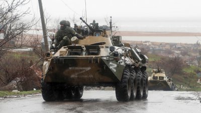 在乌克兰南部港口城市马里乌波尔，周三可见亲俄罗斯军队的军人乘坐装甲运兵车。（图取自路透社）