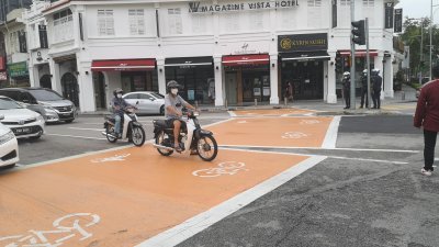 槟岛市政厅在乔治市18个道路交界处划设橙色格子，以让摩哆及脚车骑士停等交通灯。