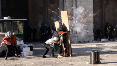 巴勒斯坦民众周五在阿克萨清真寺，与以色列警方爆发冲突。（图取自路透社）