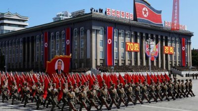 在朝鲜平壤纪念建国70周年的阅兵仪式上，士兵手持建国领袖金日成画像向前迈进。（图取自路透社）
