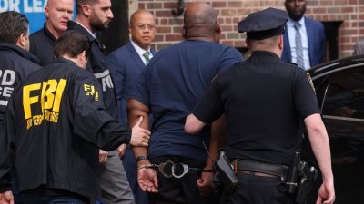 布鲁克林地铁站枪击案嫌犯詹姆斯，周三戴著手铐从纽约警察局分局被压上一辆车。（图取自路透社）