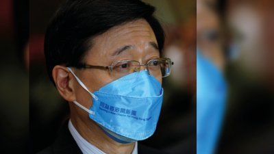 香港特首选举唯一候选人李家超在周一，首次戴上印有竞选口号“同为香港开新篇”的口罩见记者。（图取自中新社）