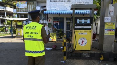 警员周三在拉姆布卡纳一个受到破坏的加油站进行调查。（图取自法新社）