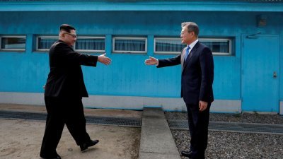 2018年4月27日，韩国总统文在寅（右）和朝鲜最高领导人金正恩在非军事区板门店休战村，隔著韩朝分界线握手。（路透社档案照）