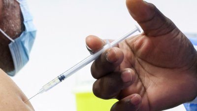 在比利时布鲁塞尔一个疫苗接种中心，一名男子今年1月5日注射辉瑞（Pfizer）疫苗的加强针。（图取自路透社档案照）
