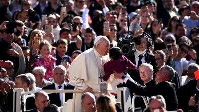 罗马天主教教宗方济各当地时间周三，抵达梵蒂冈圣彼得广场时亲吻一名小孩。（图取自法新社）