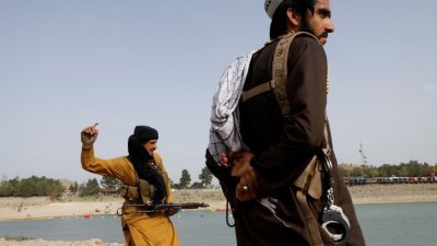 塔利班战士素有与伊朗边防人员起冲突的历史。图为两名塔利班战士站在喀布尔的卡格哈湖旁。（图取自路透社）
