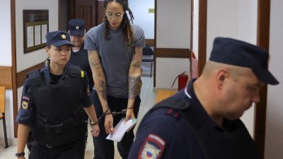 上了手铐的美国女篮球星格里纳于周四，由厅警羁押出庭听取审判。（图取自路透社）