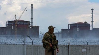 俄罗斯占领乌克兰扎波罗热州核电站已经5个月。一名穿着印有俄罗斯国旗的军人在核电站外守卫。（图取自路透社）