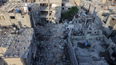 在以色列对加沙地带南部拉法的一夜空袭之后，巴勒斯坦人周日在一座建筑物的废墟中搜寻。以军表示，杰哈德在加沙南部指挥官曼苏尔在行动中被炸死。（图取自法新社）