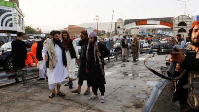 爆炸发生后，塔利班战士在爆炸现场维持秩序。（图取自路透社）
