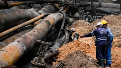 Cupet国家石油公司的员工周三在储油基地检查损坏情况。（图取自法新社）