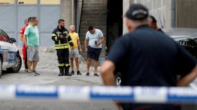 黑山的执法人员在枪击现场拉起警戒布条，远处可见居民正与执法人员沟通。（图取自路透社）