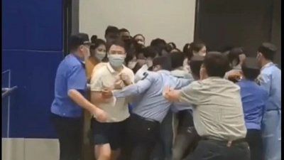 网上流传的视频显示，为避免被隔离，民众奋力推开大门，企图逃离商场。（图取自台湾《联合报》）