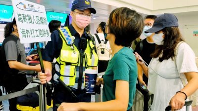 有鉴于近期民众至柬埔寨打工遭诈、被囚案频传，台湾警方在机场持手牌宣导，并主动关怀询问，了解出境的目的动机。（图取自中央社）
