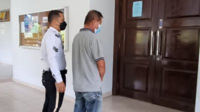 醉酒驾驶的被告（右），被押往芙蓉法庭面控时俯首认罪，被判入狱14天及罚款一万令吉。