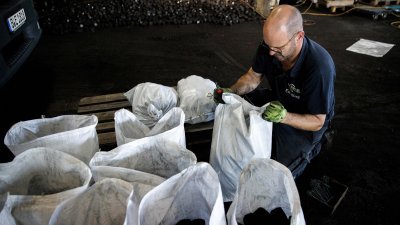 柏林汉斯恩格尔克能源公司的一名工人，在仓库中将煤炭装袋。（图取自法新社）