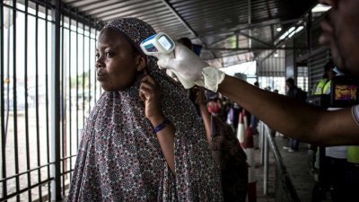 一名从卢旺达入境的妇女在埃博拉病毒检测中心接受筛查，通过检测后才获准进入刚果（金）。（图取自法新社）