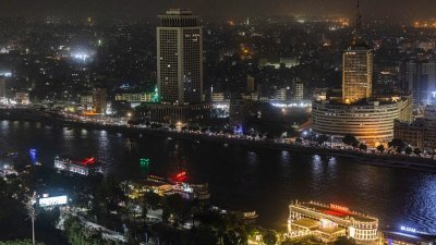 最近埃及外汇储备枯竭，政府开始调暗建筑物灯光，以省下能源来拼出口。图为夜间的开罗地标性建筑开罗塔，（从左到右）埃及外交部总部和埃及广播电视联盟广播总部，晚间照明很明显调暗了。（图取自法新社）