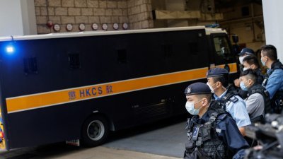 香港《苹果日报》创办人、媒体大亨黎智英周四据信乘坐囚车，到达香港高等法院，开始他的国安法案件审理。有多名警员在囚车出口附近驻守戒备。（图取自路透社）
