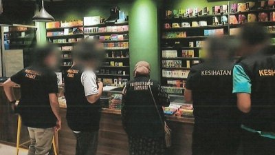 马六甲卫生局药剂执法组的执法人员检查电子烟店内的产品。（照片由当局提供）