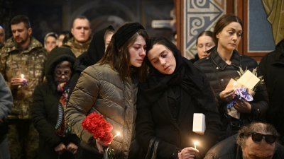 一场在乌克兰首都基辅一座教堂举行的葬礼上，神情哀伤的亲友送别一名阵亡的乌军士兵。（图取自路透社）