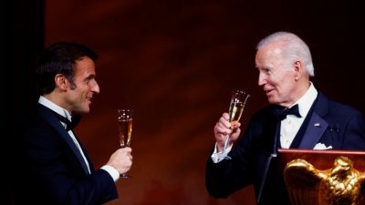 美国总统拜登周四在白宫设国宴，招待前来访问的法国总统马克龙。图中两人手持酒杯，相互敬酒。