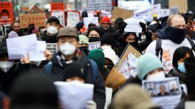在德国首都柏林，抗议者当地时间周六手持标语牌和白纸，声援中国的反封控示威浪潮。（图取自路透社）