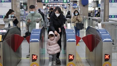 自12月5日（周一）首班车起，北京巴士、地铁运营企业在核验健康信息时，不得拒绝无48小时核酸阴性证明的乘客乘车。图为北京市民周一乘坐公共交通出行。（图取自中新社）