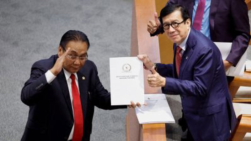 在周二举行的国会全体会议上，印尼法律和人权部长Yasonna Laoly（右）收到了监督修订的国会委员会主席Bambang Wuryanto的《刑法修正草案》报告。（图取自路透社）