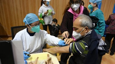 在广州市花都区人民医院新冠肺炎疫苗接种点，一名老年人周二接种疫苗。目前，广州有序开展新冠肺炎疫苗接种工作。（图取自中新社）