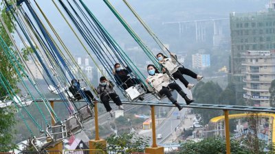 重庆涪陵红酒小镇景区周四恢复开放，游客在景区内玩耍游乐设施。（图取自中新社）