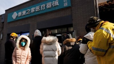 在北京一家药房外，民众周三冒著严寒排队购买药物。（图取自路透社）
