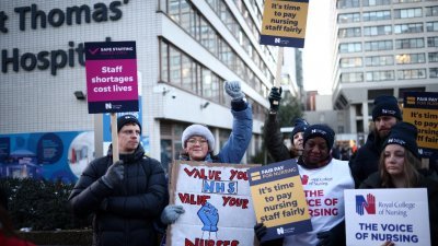 在英国首都伦敦市中心的圣汤玛斯医院外，罢工的护理师高喊口号及高举标语，为争取更好的薪资及工作条件。（路透社）