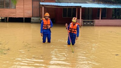 民防部队在水灾地区测量水位。（档案照）
